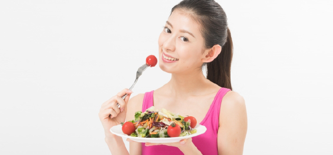 野菜類をたくさん食べている女性